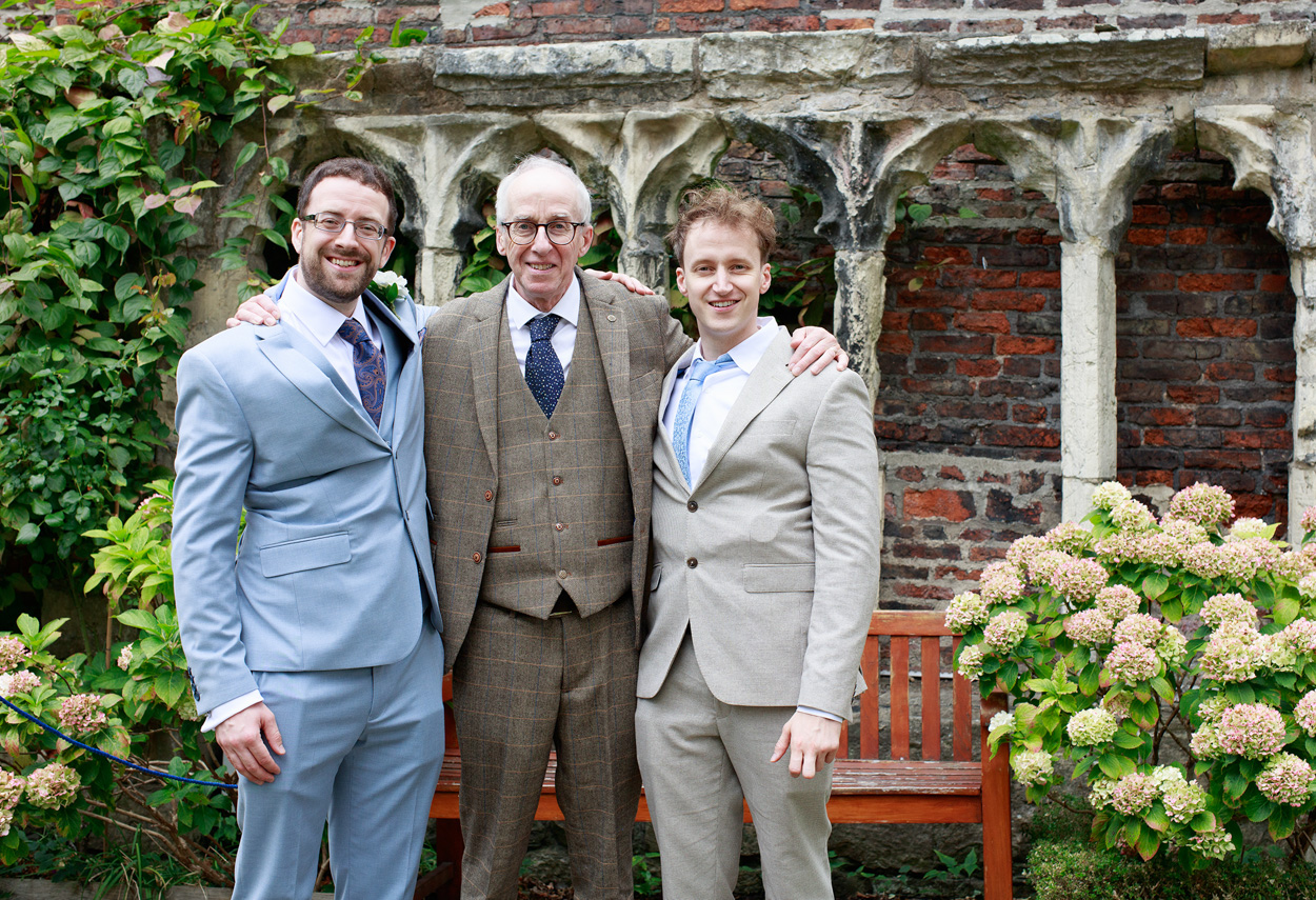 David stands with his brother and father, sharing a quiet moment before the ceremony.
