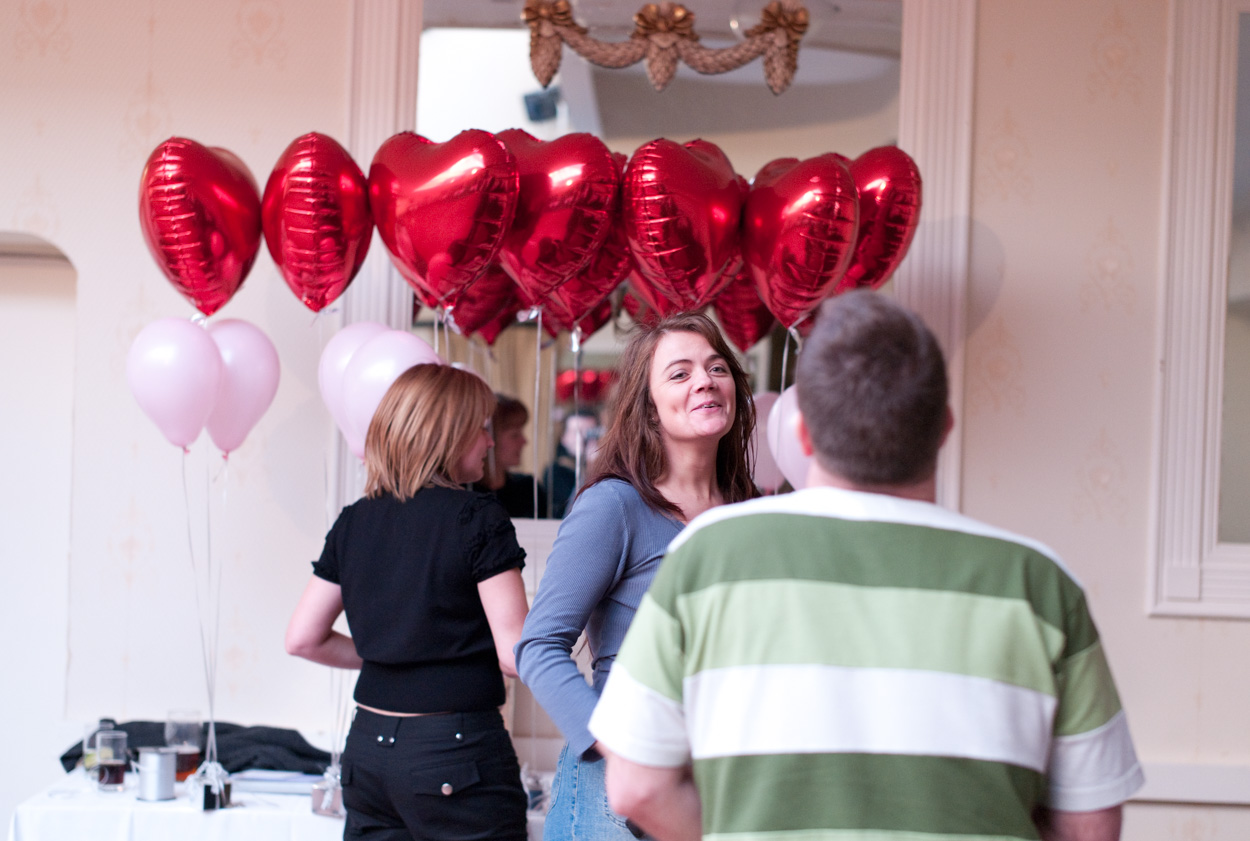 Red heart and white balloons as the bride’s sister smiles at Stirk House