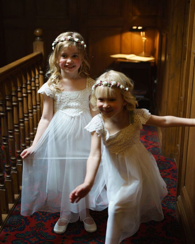 Young bridesmaids posing, one playfully trying to escape the camera’s view Caption:
