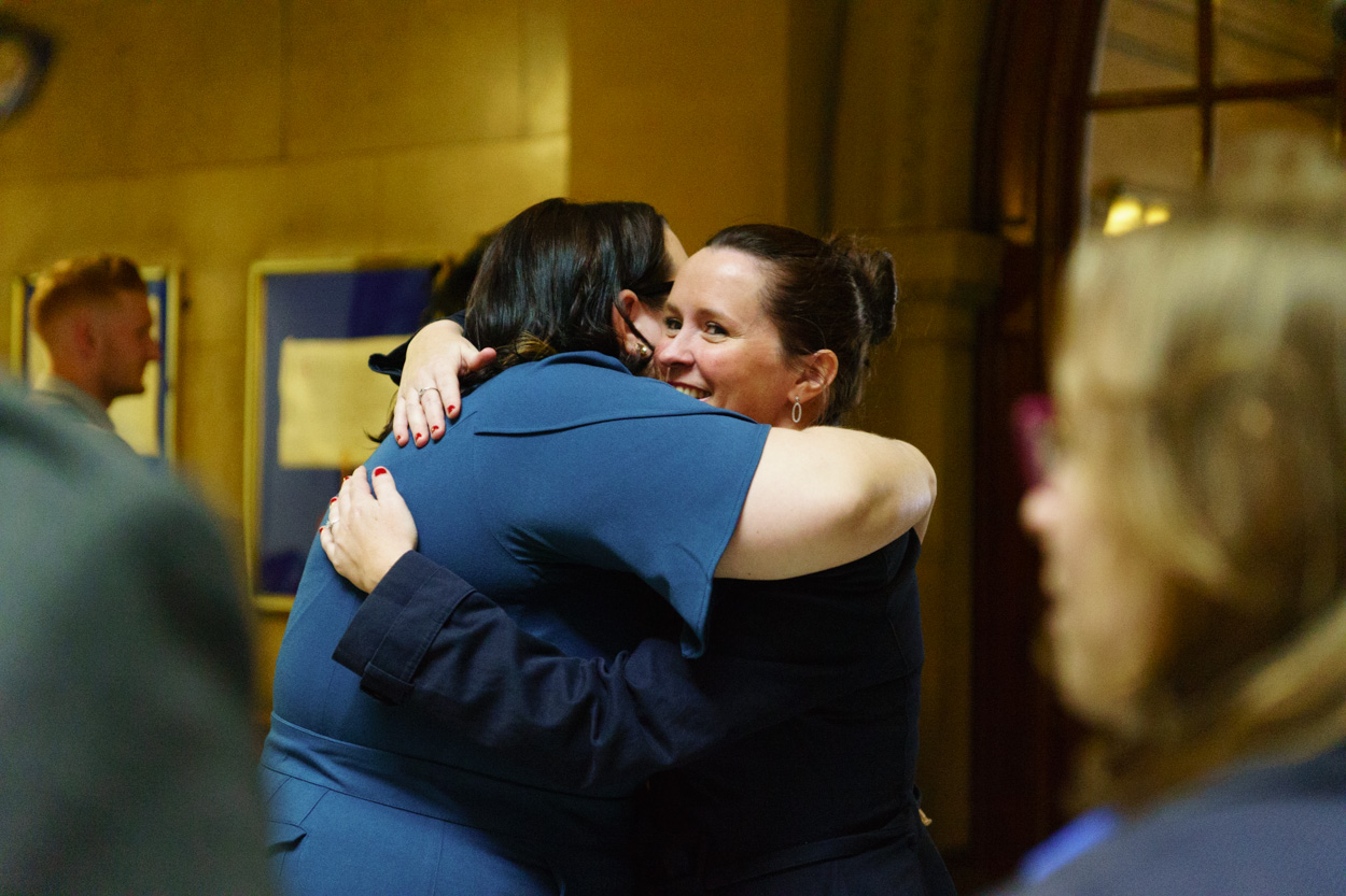 Tamara hugging a smiling friend inside the warm interior