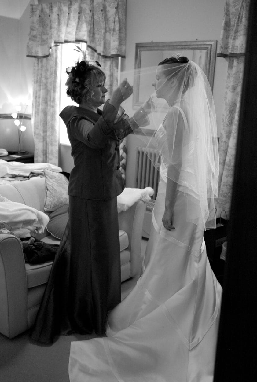 Emelie closes her eyes in thought as her mum adjusts her veil.
