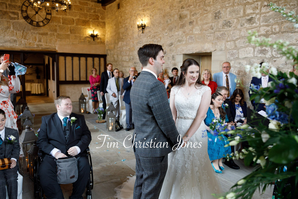 Tender moment during The Priests House ceremony as couple hold hands.