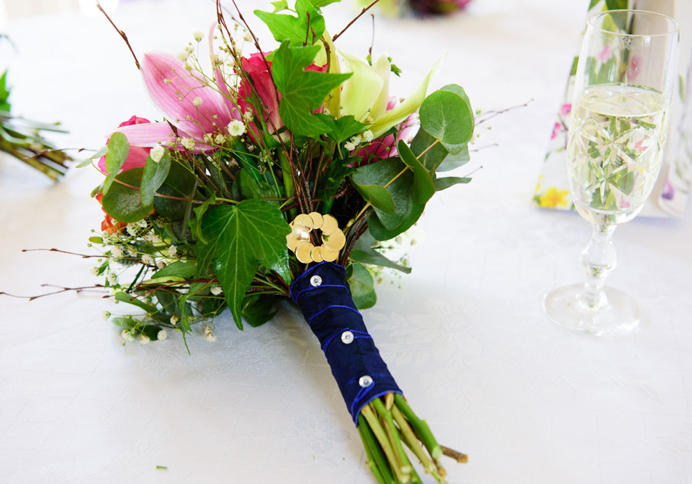 Close-up of bridal bouquet with purple ribbon detail — West Yorkshire wedding flowers.