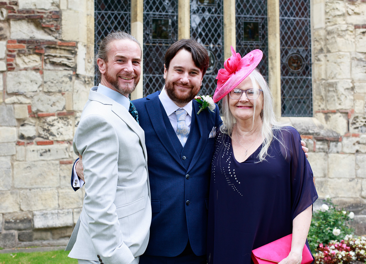 Chris stands with family, looking toward the camera with proud expressions.