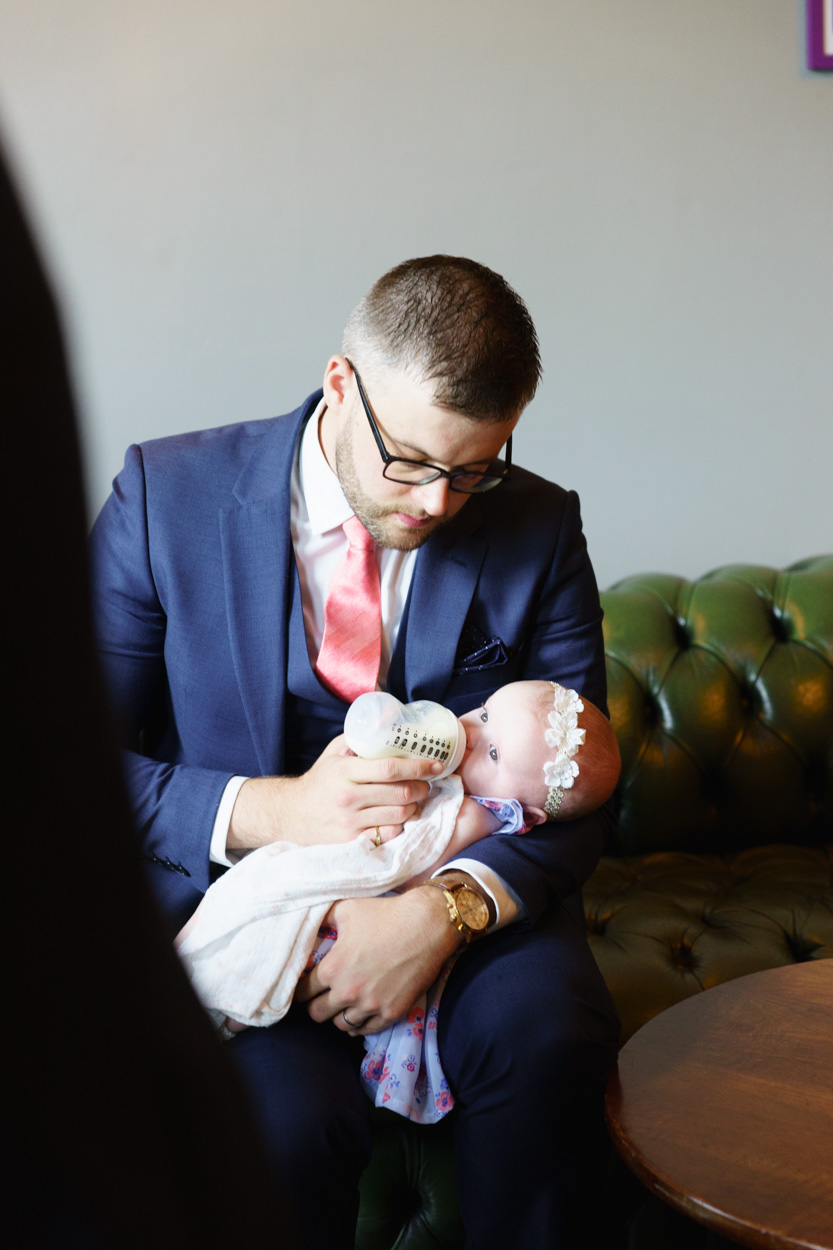 Father feeding his baby daughter during wedding celebrations