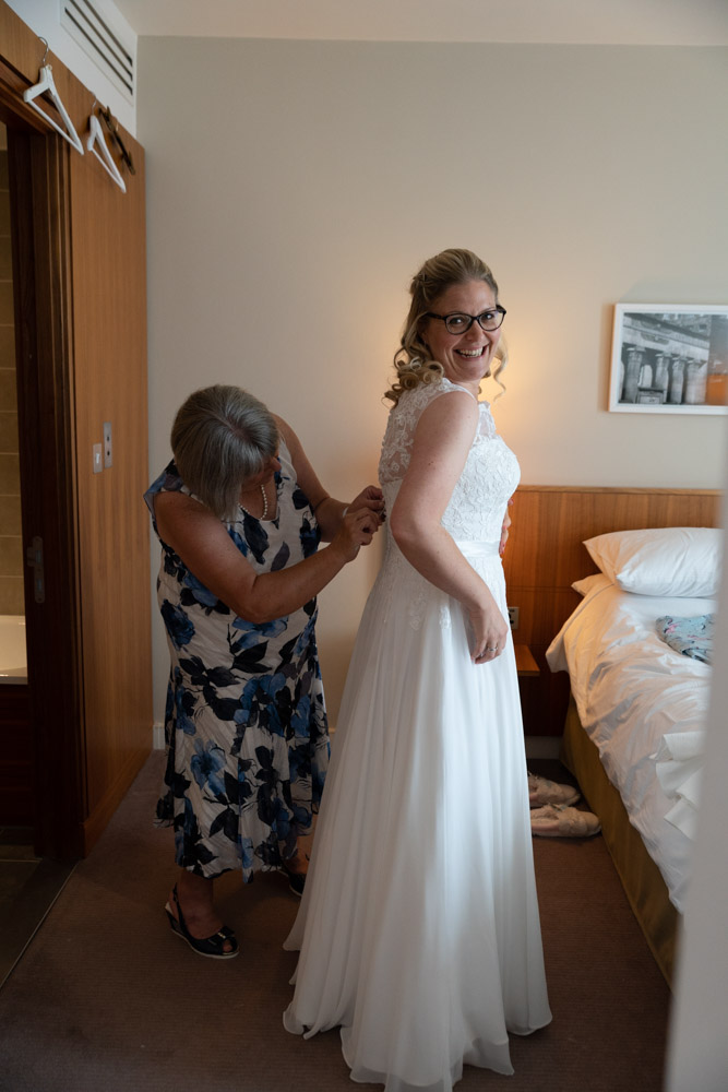 Clare’s mum ties the final lace of her wedding dress