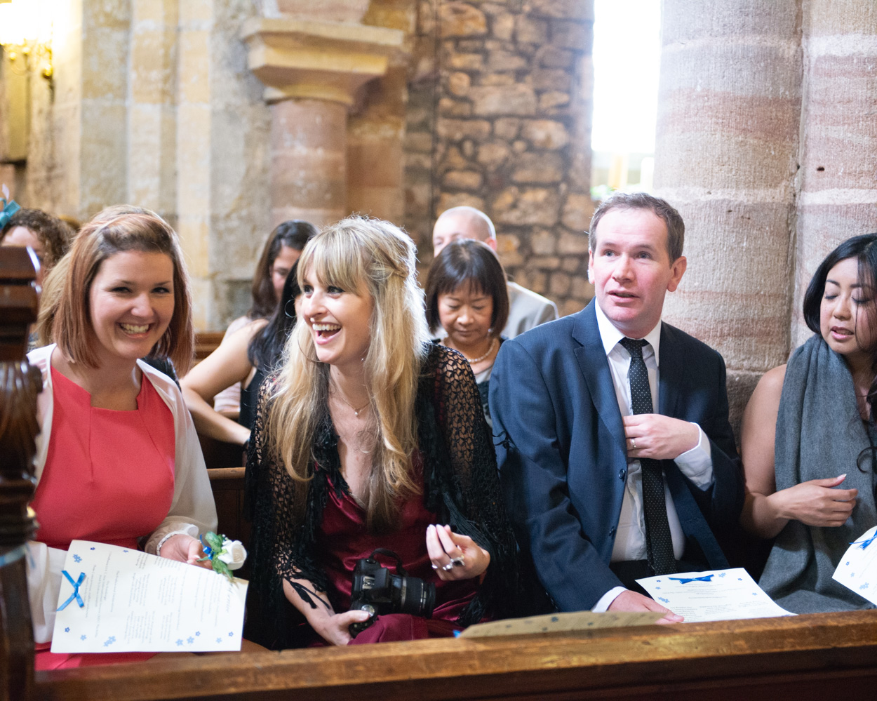 Guests seated in the pews smiling during the ceremony