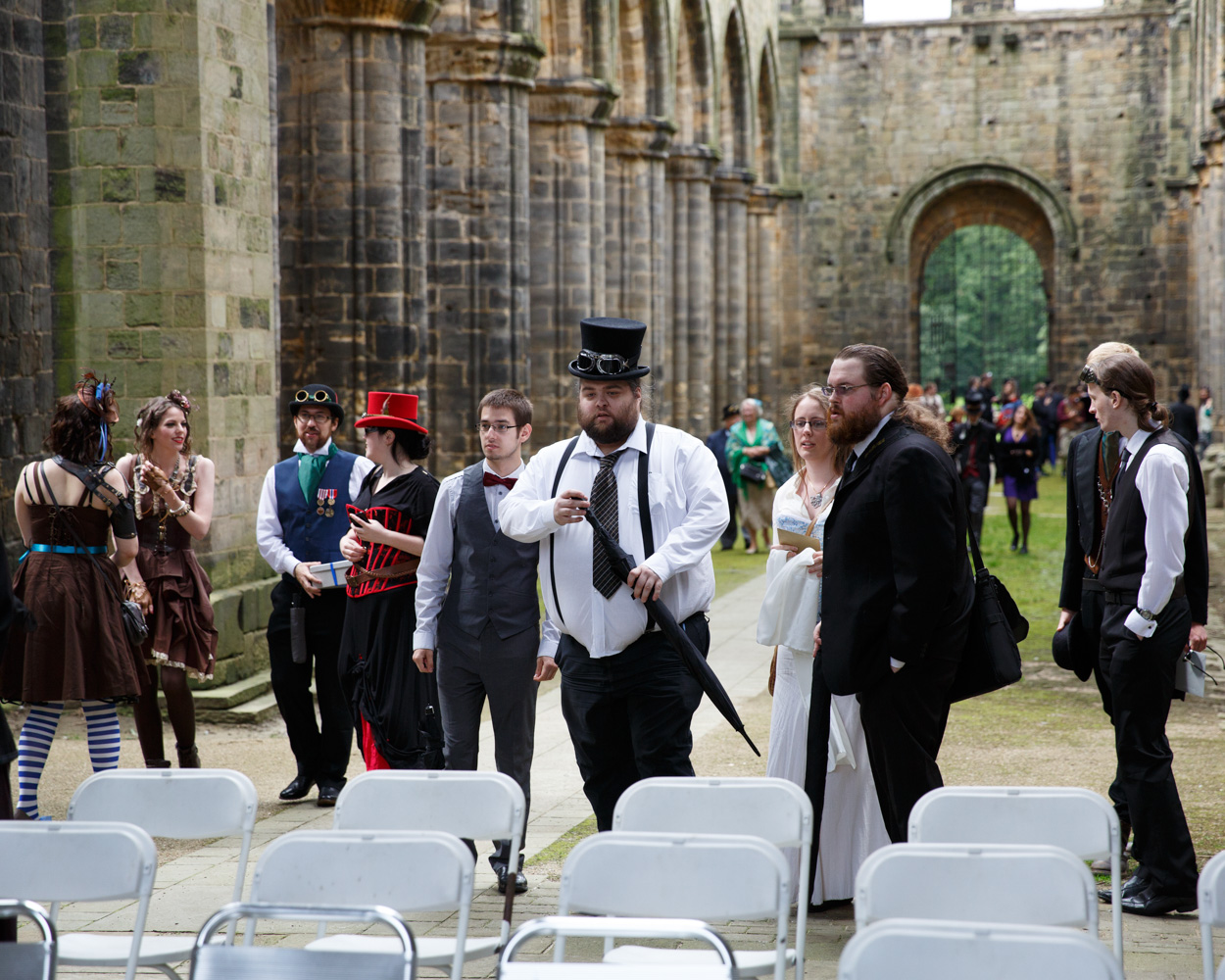 Wide view of Kirkstall Abbey church with folding chairs set as guests take their seats