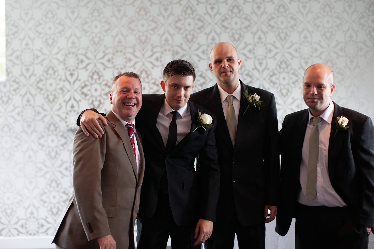 Groom and groomsmen huddle together for a natural, relaxed group photo.