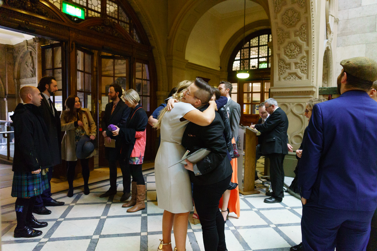 Wide view of Sheffield Town Hall interior as guests gather and hug