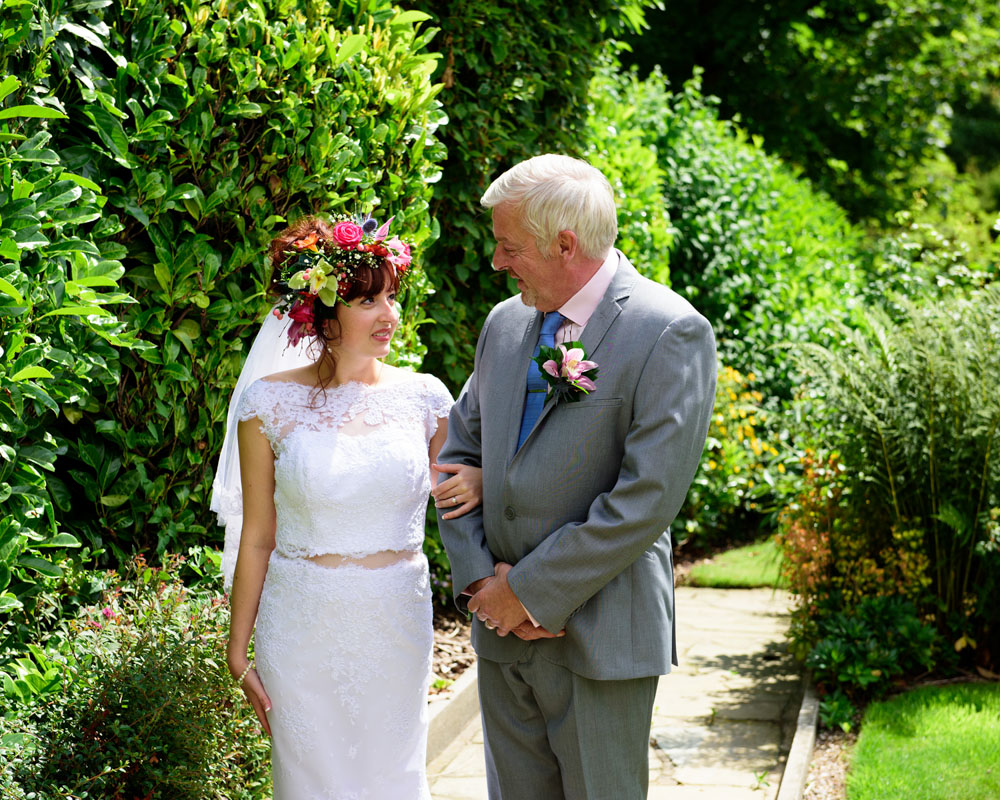 Father of the bride looks at Chloe — flowers in her hair, joy in her eyes.
