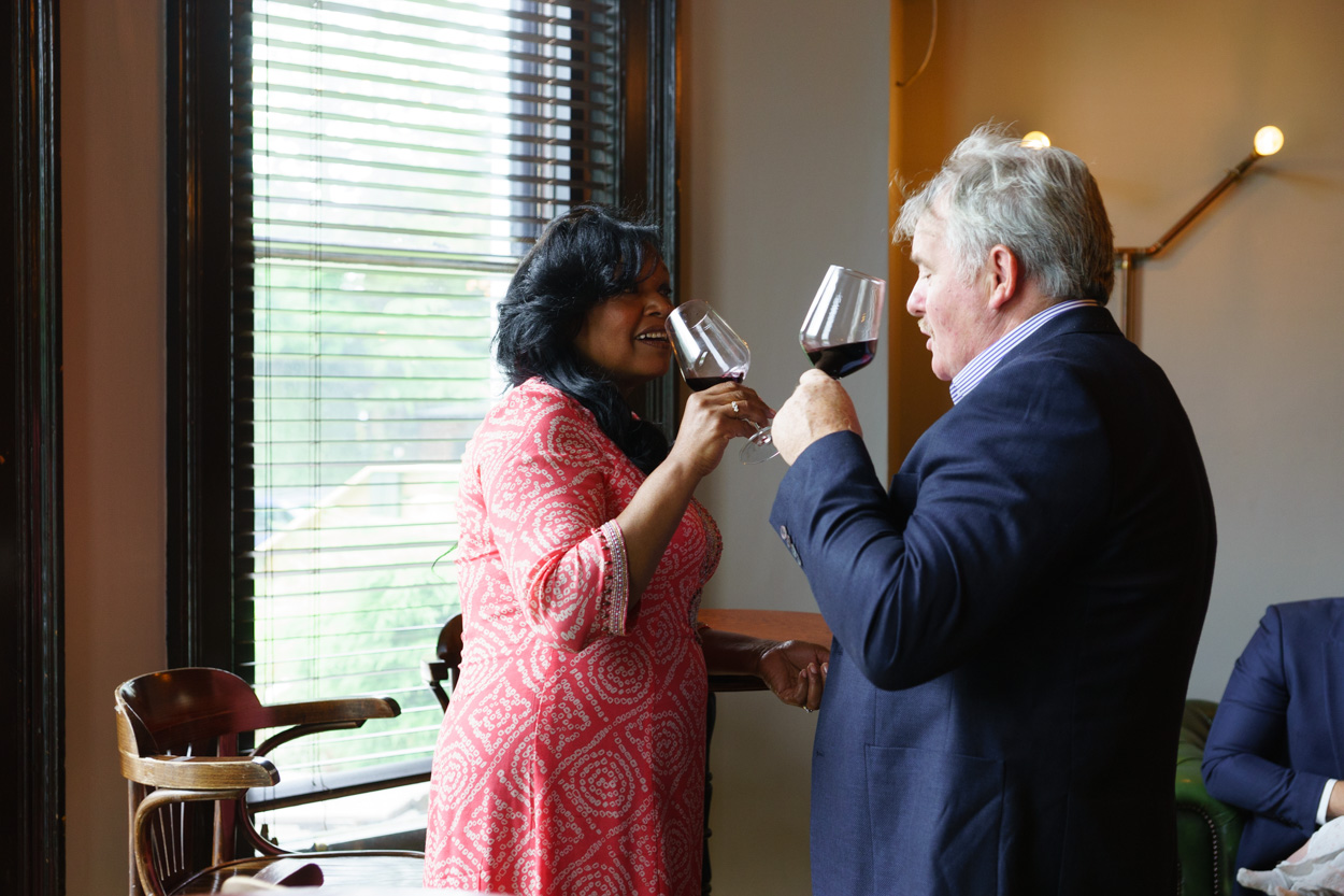 Couple clinking wine glasses before a wedding ceremony