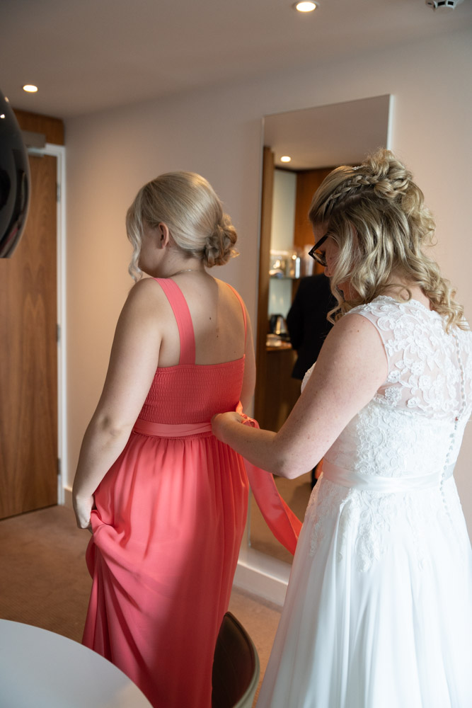 Clare helps her daughter tie the ribbon on her bridesmaid dress