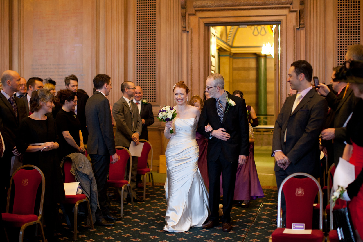 Bride entering the Banquet Hall on her father’s arm as bridesmaids follow.