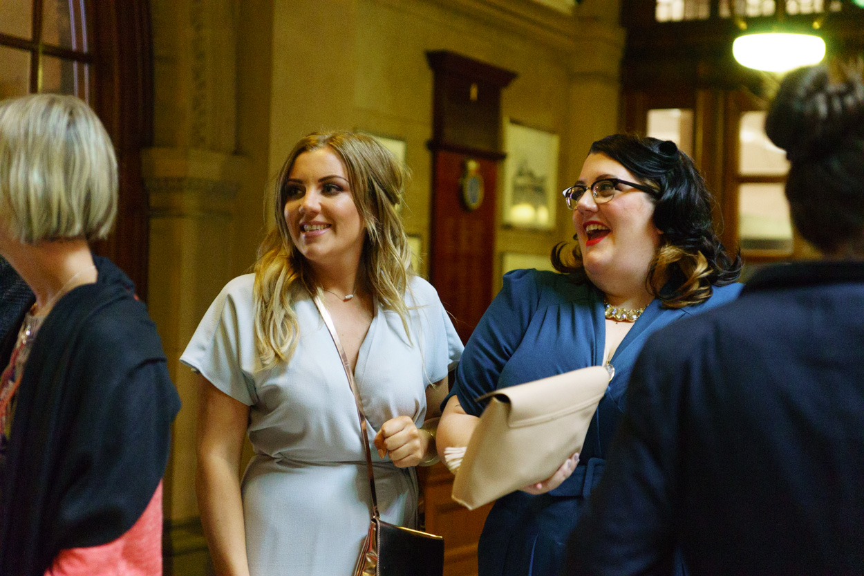 Lizzie with her sister smiling among guests inside the Town Hall