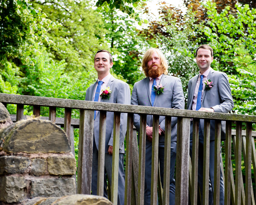 Groom and groomsmen standing on a wooden bridge at St Paul’s Church, West Yorkshire.