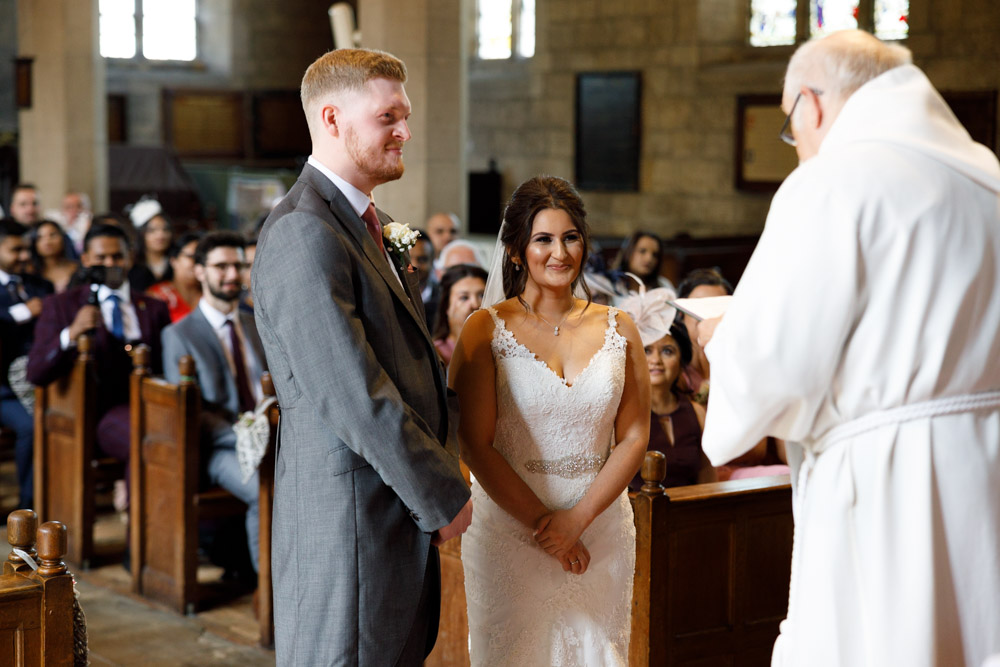 The couple smile softly as the minister reads heartfelt words during the ceremony.