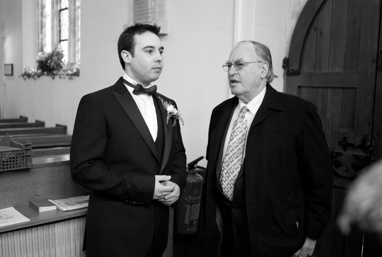 The groom waits at St Andrew’s Todber in monochrome.