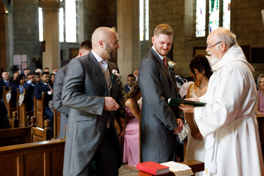 Best man adds a touch of humour as he jokes with the minister about the rings.