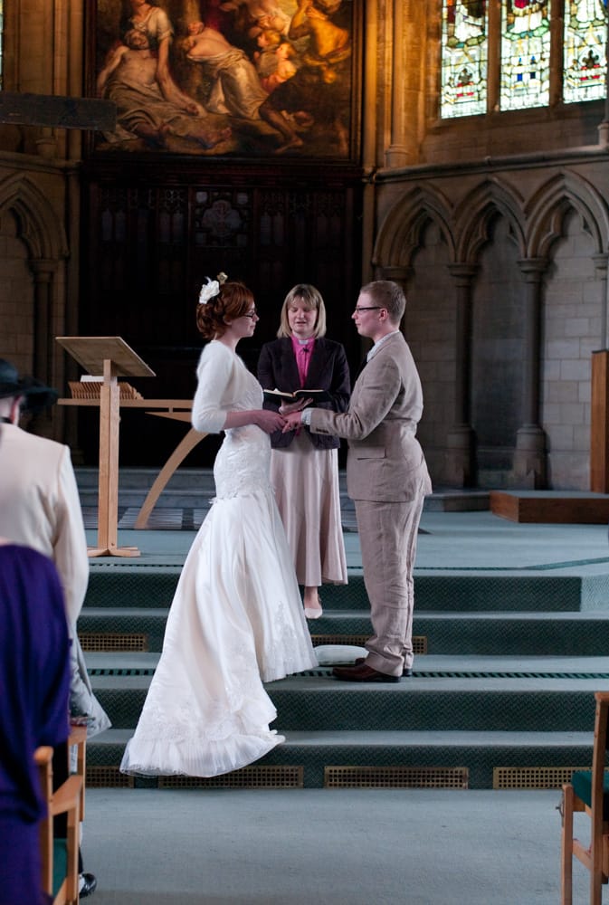 Groom placing wedding ring on bride’s hand during St George’s Leeds ceremony.
