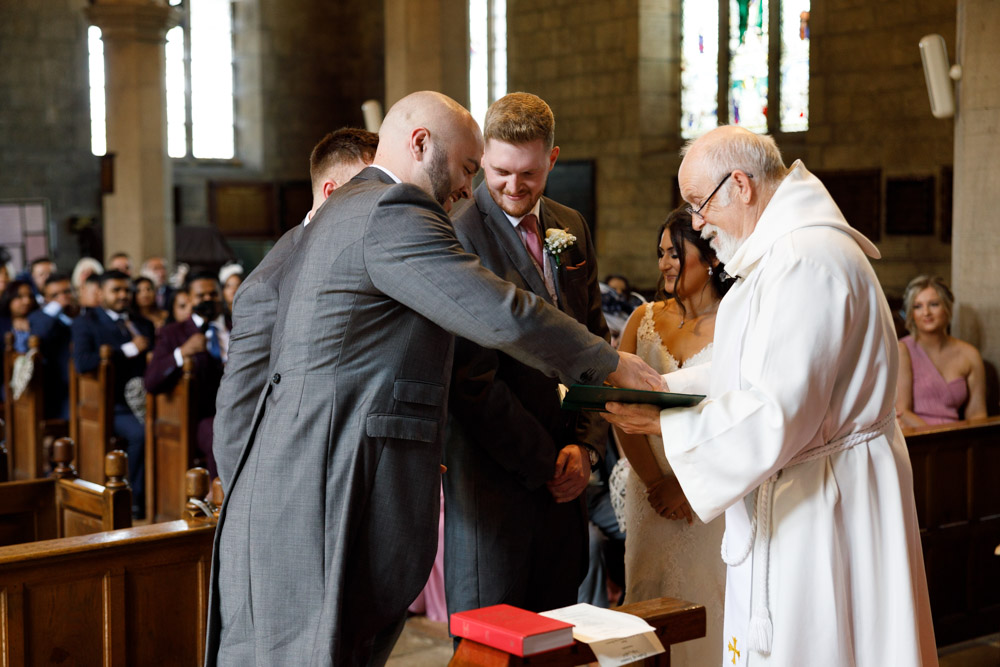 The wedding rings are placed gently onto the minister’s service book by the best man.