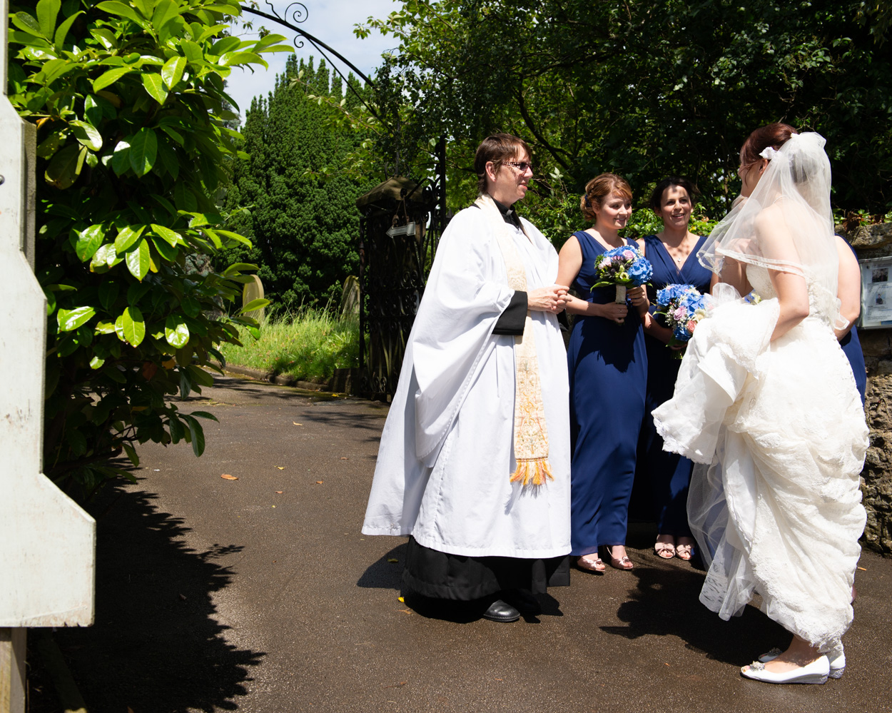 Bride meets the vicar at the church gate before the ceremony