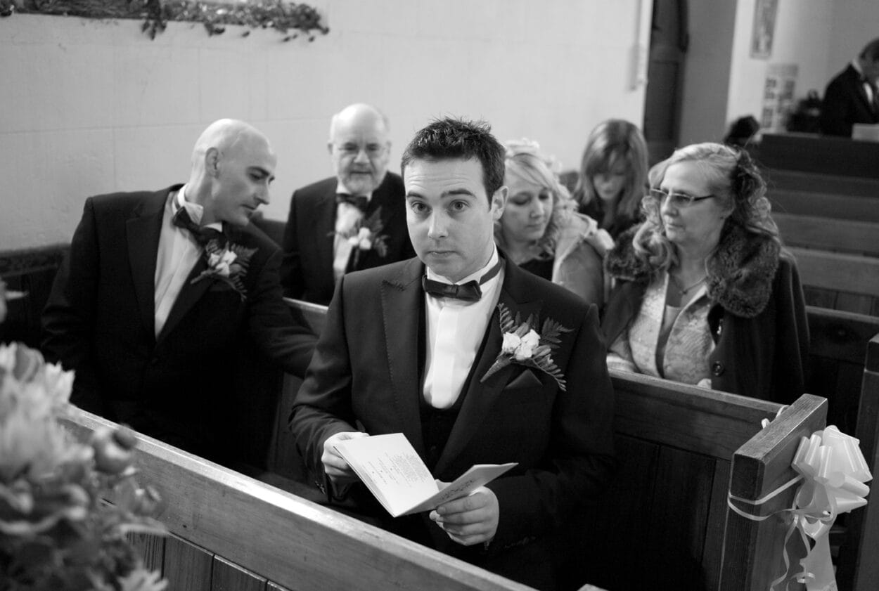 Groom looks up with a slightly nervous expression.
