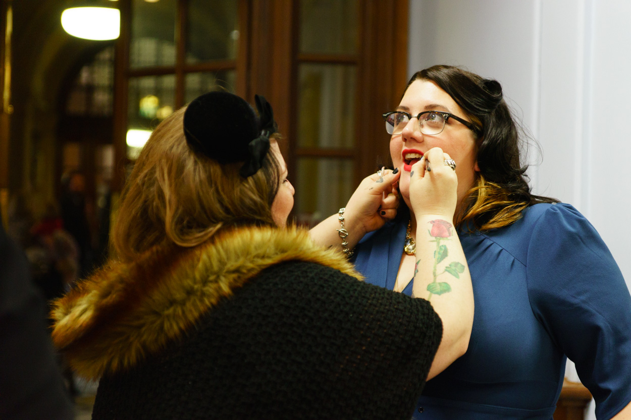Friend helping Lizzie with lipstick before the ceremony
