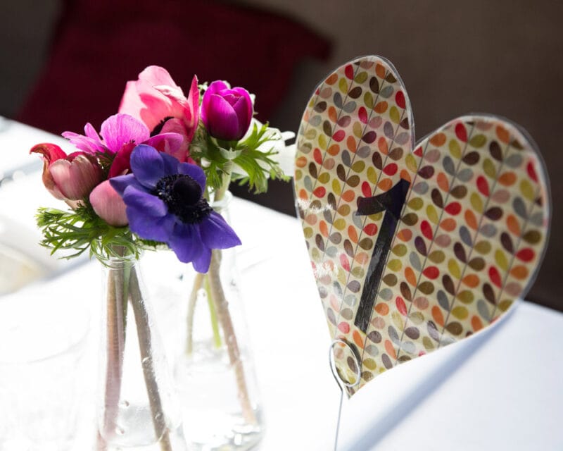 Table setting with a heart-shaped table number and floral centrepiece