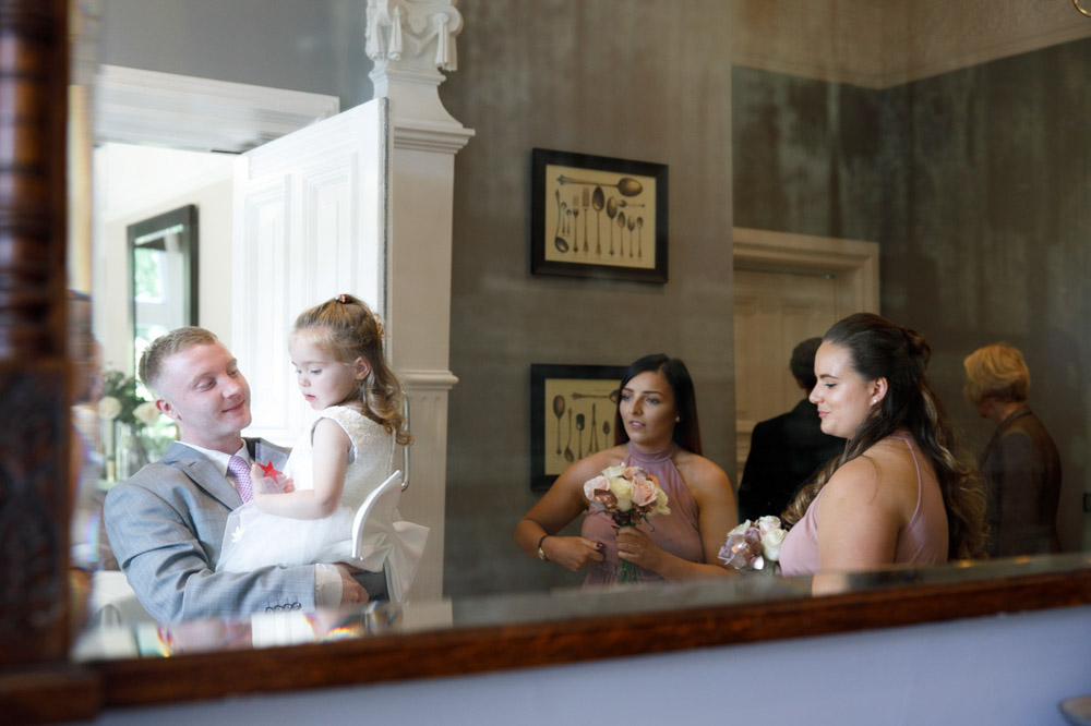 Bridesmaids and guests reflected in the mirror before the ceremony