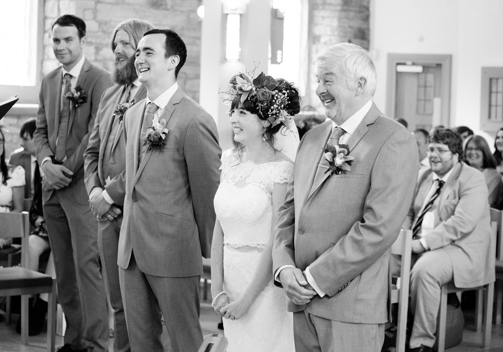 Wedding party smiling at something the minister says during the ceremony.
