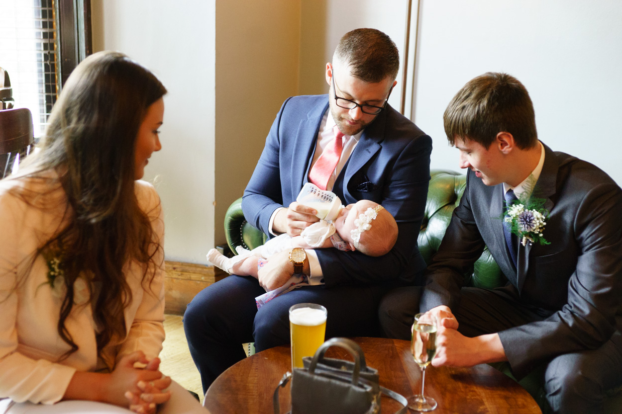 Guests admiring a baby during wedding drinks