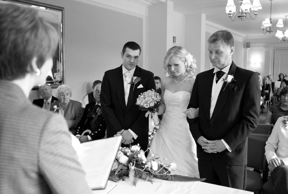 Dani looks down as the ceremony begins, emotion on her face