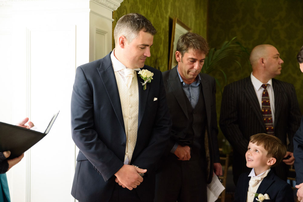 Groom looks down at his young son and they share a smile before the ceremony.