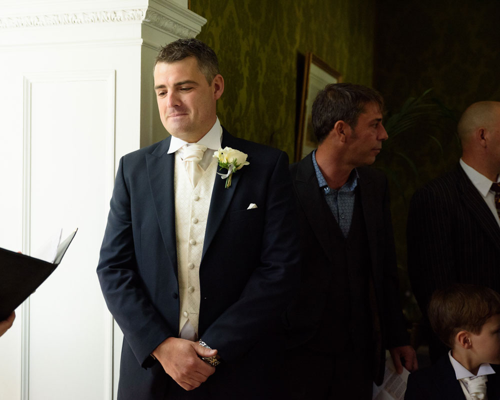 Groom turns calmly to the registrar and smiles before the ceremony begins.