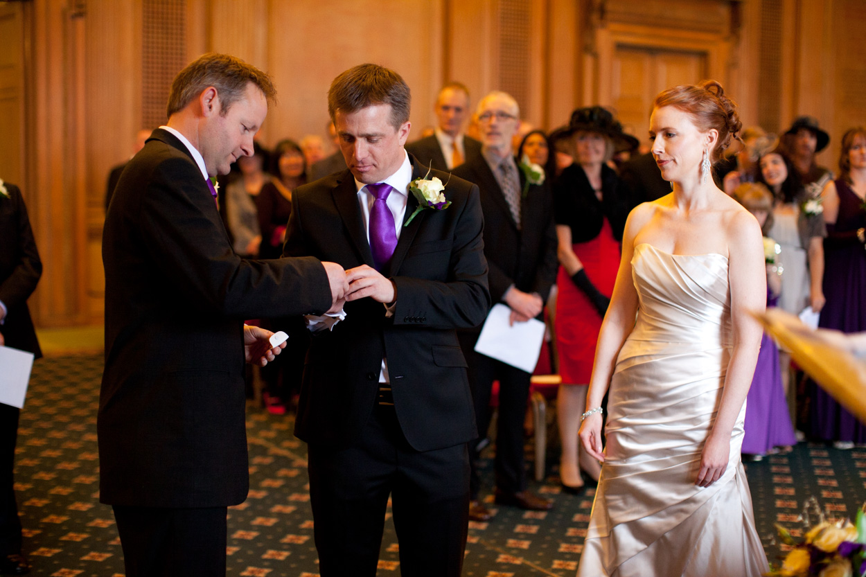 Best man passing the bride’s ring to the groom during the ceremony.