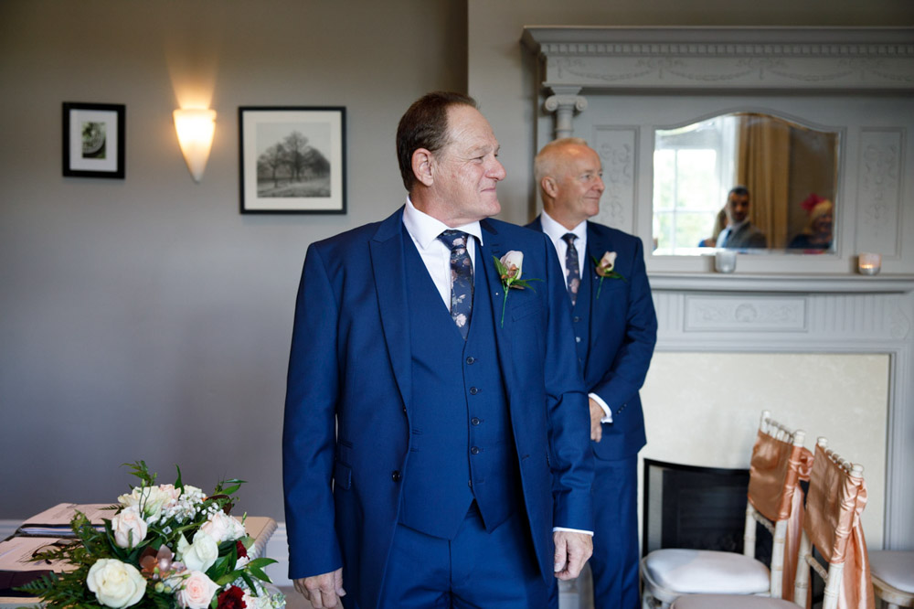 Groom and best man glance proudly down the aisle
