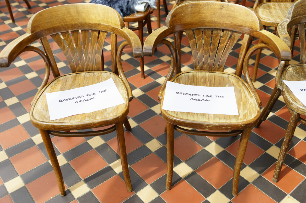 Reserved ceremony chairs set in a conservatory wedding venue