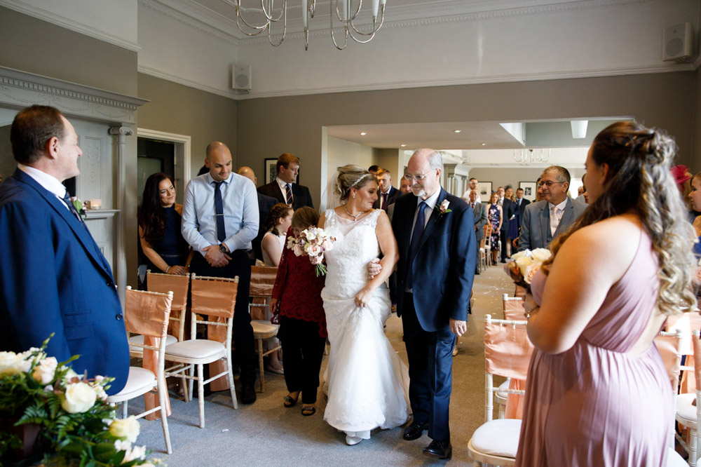 Tracy walks down the aisle with two elderly relatives