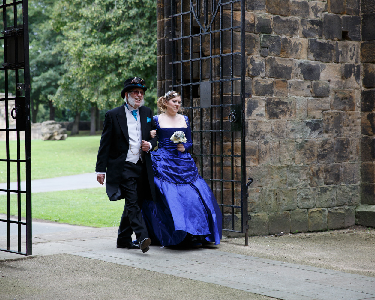 Father and daughter walk through the Abbey gates together, pride and nerves mixing as the ceremony approaches