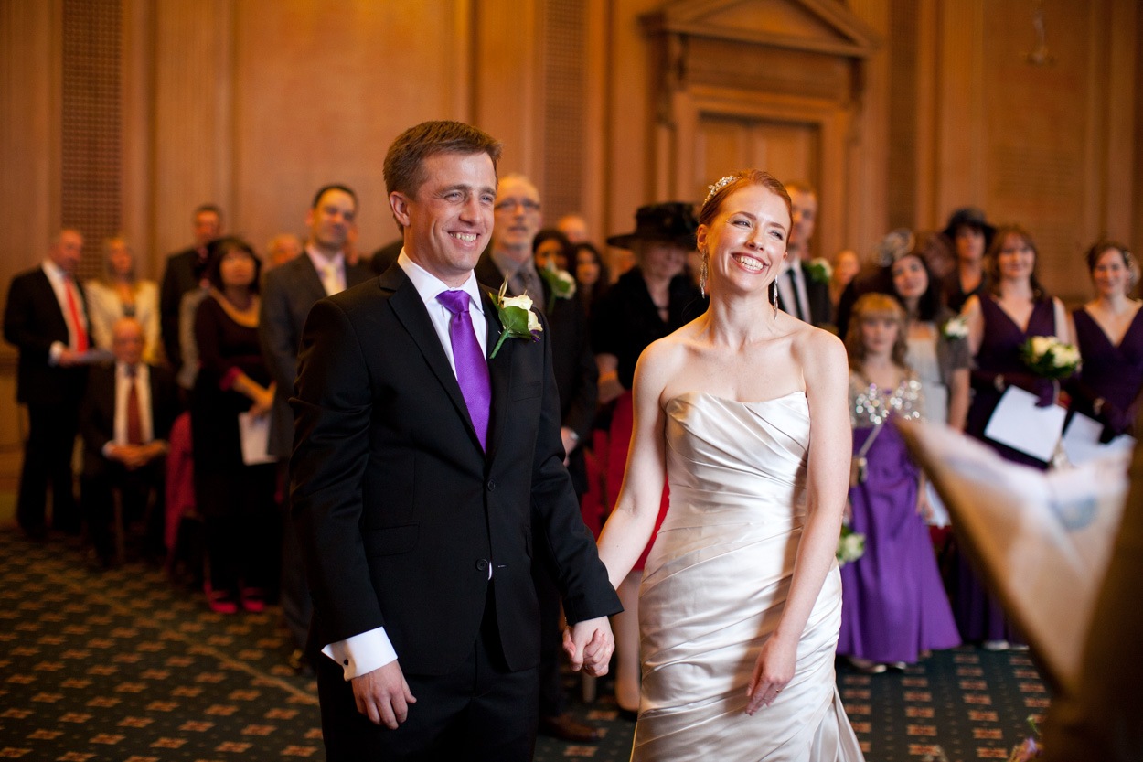 Bride and groom smiling broadly as the registrar announces them married.