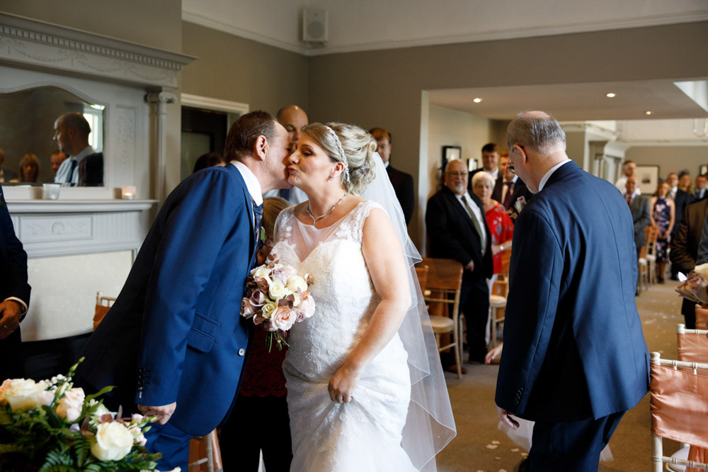 Couple steal a quick kiss during the ceremony