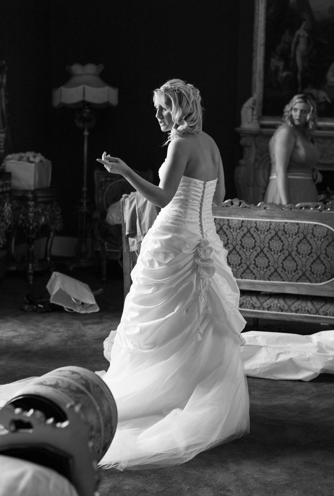 Bride in her dress looking back naturally, caught in a quiet black and white moment.