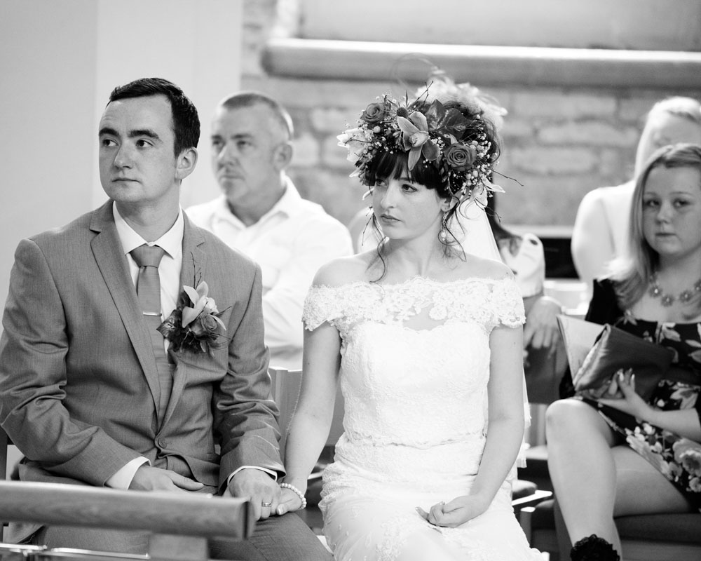 Bride and groom seated inside St Paul’s Church, listening to the final blessing.