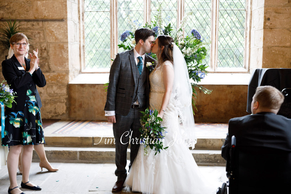 Romantic Yorkshire wedding moment as the newlyweds kiss before leaving the ceremony at Barden Tower.