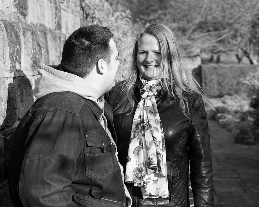 Lisa smiling warmly in the dappled evening sunlight at Kirkstall Abbey.