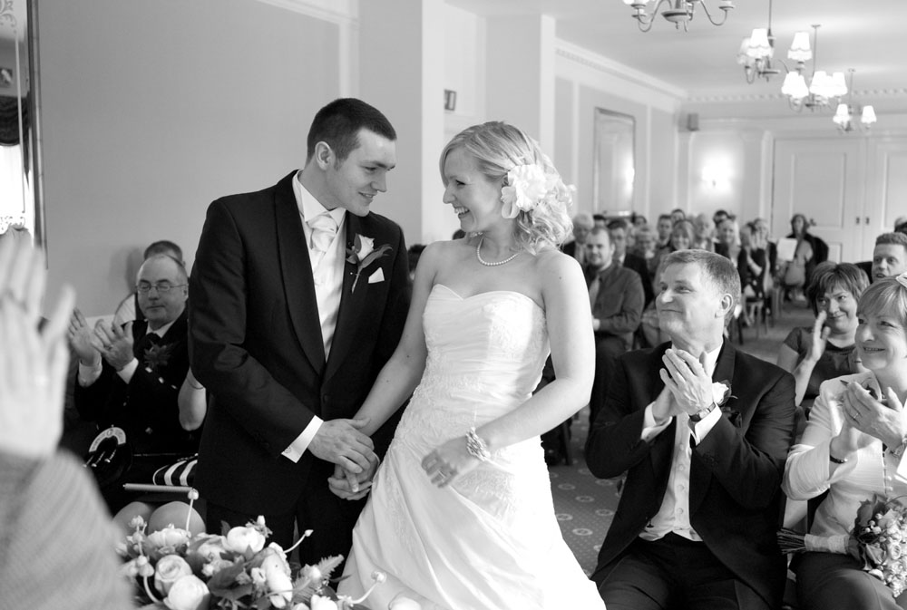 Dani and Scott smile as guests applaud after their vows