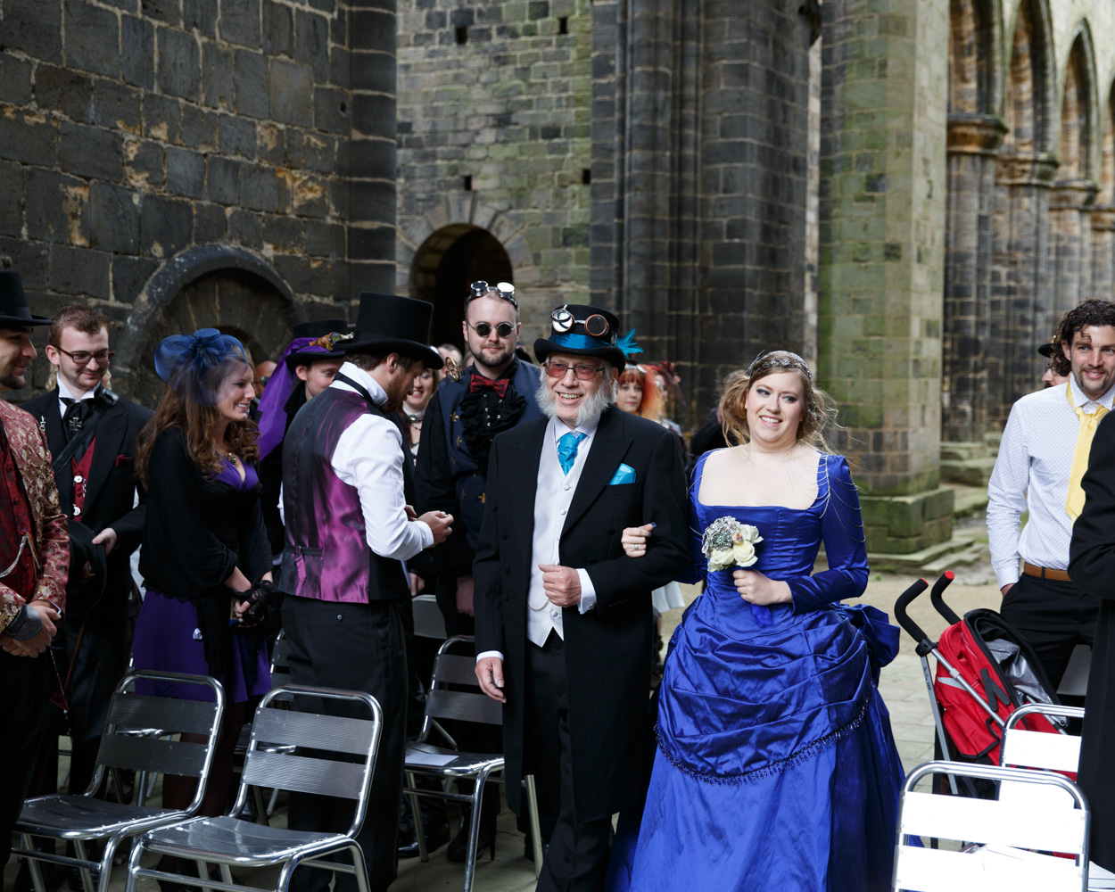 The bride looks out across family and friends as she reaches the ceremony space