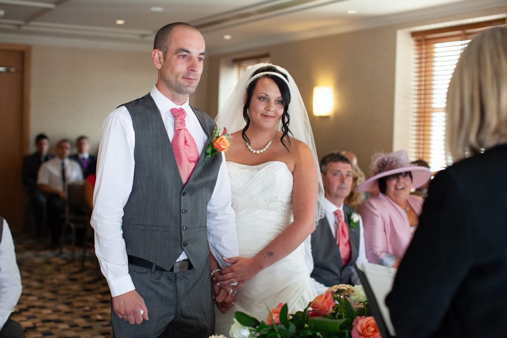 Dave and Gemma smile as the registrar begins the ceremony.