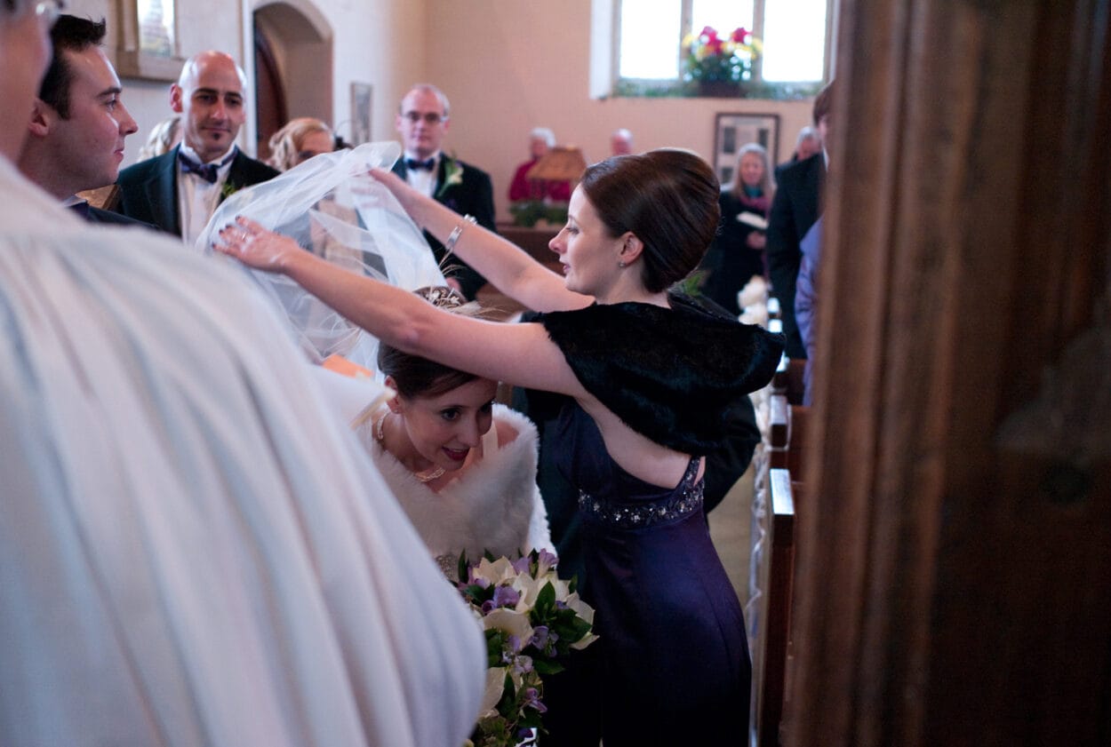 Emelie ducks as her sister removes the veil from her face.